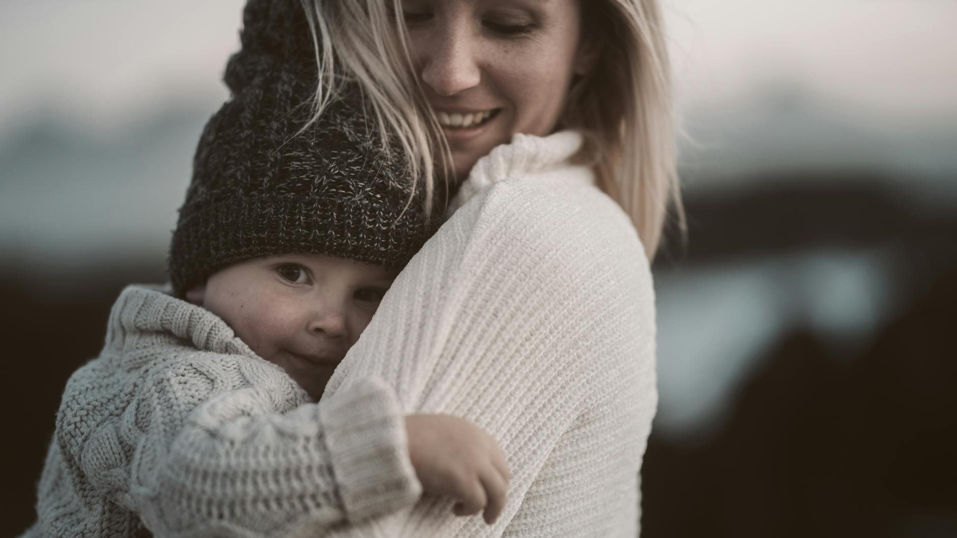 Poème pour maman pour la fête des mères : des mots tendres pour tous les âges — mère et enfant s'enlaçant en extérieur