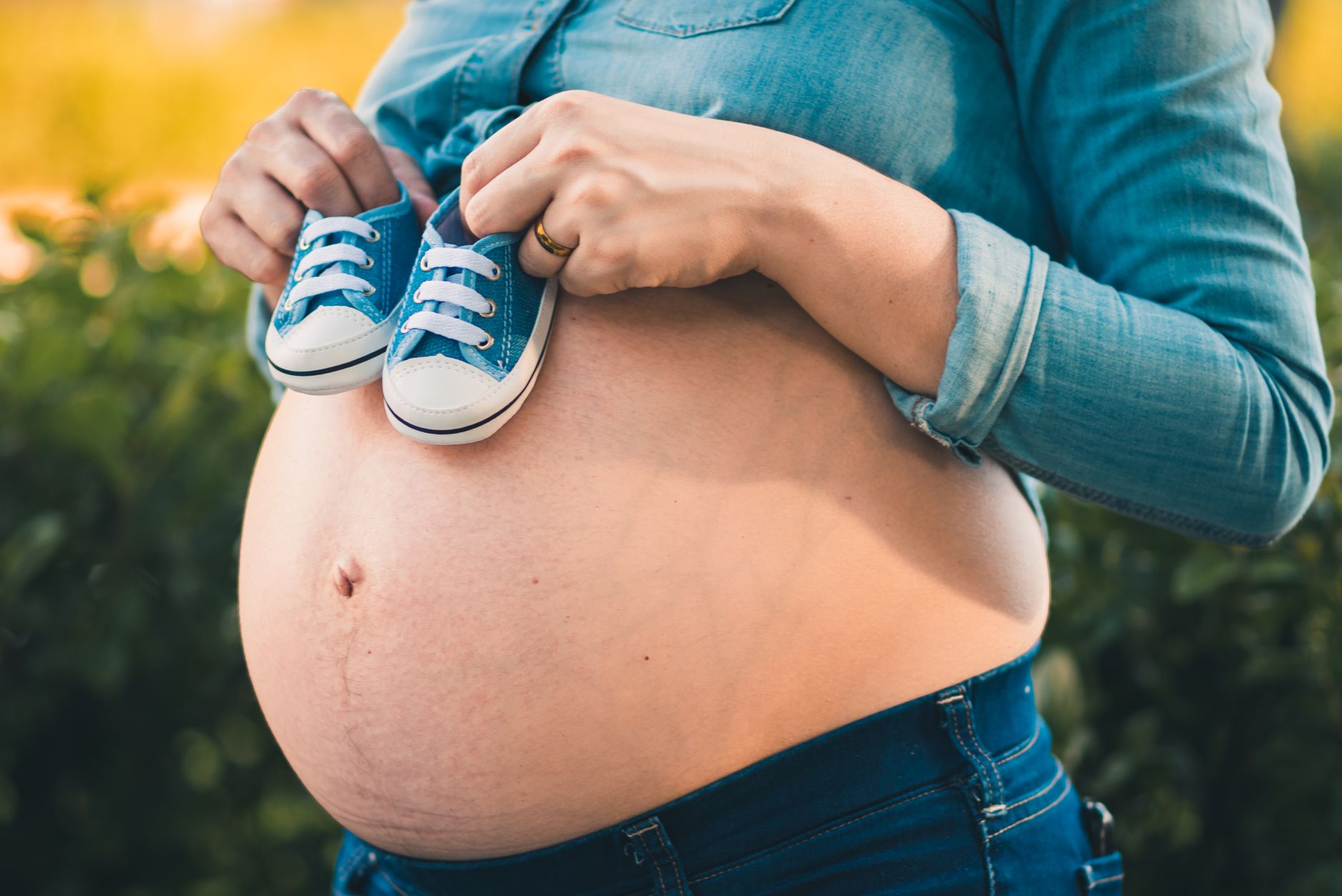 Sarah Knafo enceinte ou pas enceinte : remettre les choses à plat — femme enceinte tenant des chaussures de bébé