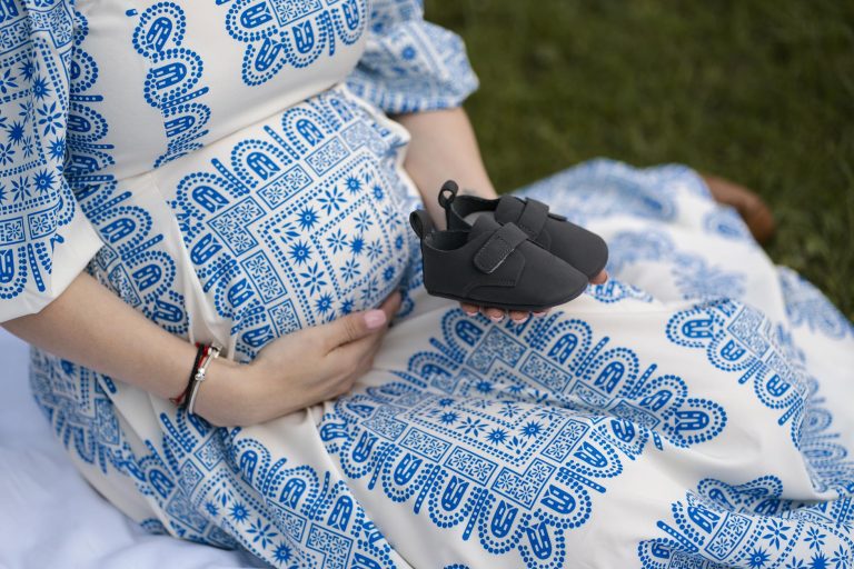 Sarah Knafo est-elle enceinte ? — femme enceinte tenant des chaussures de bébé