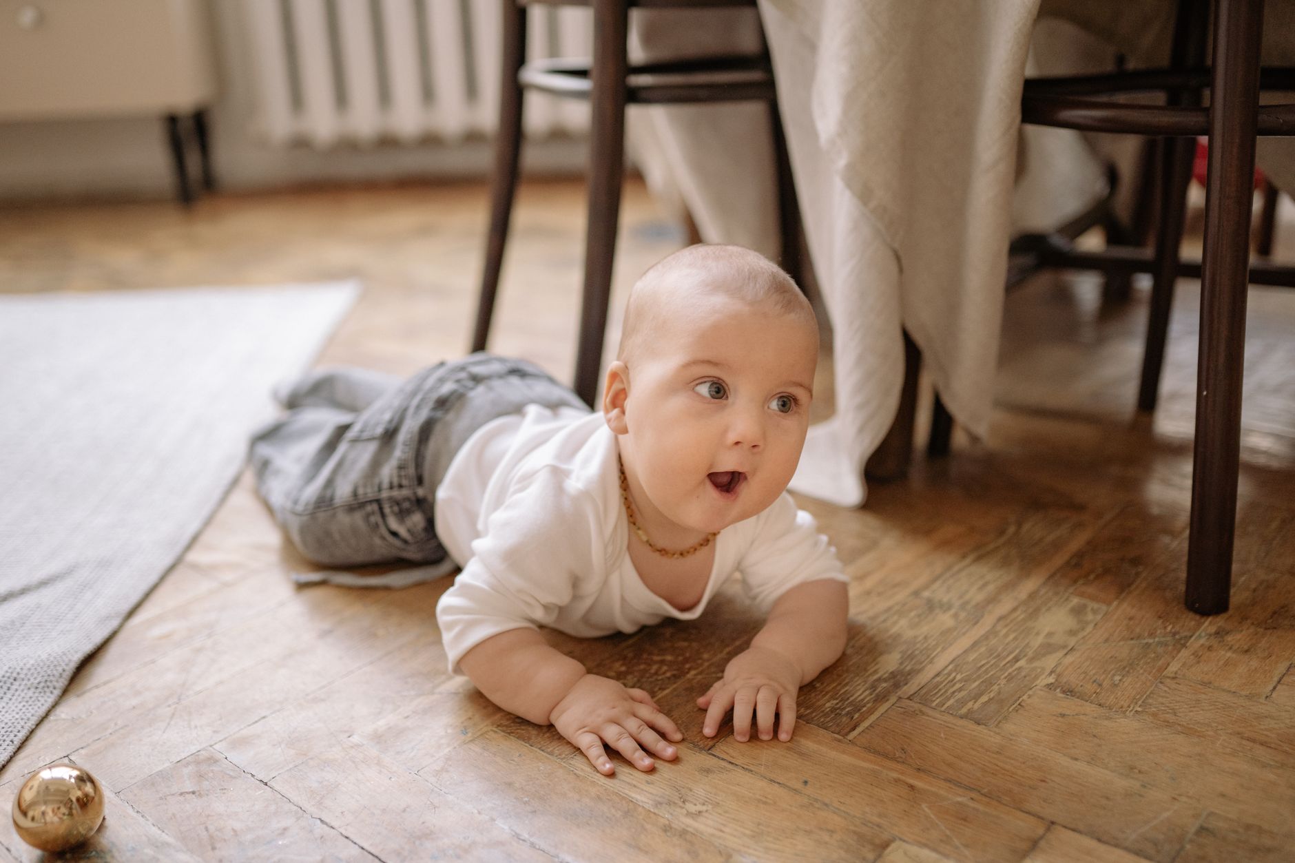 Nourrisson : définition médicale, repères d’âge et besoins spécifiques — bébé heureux jouant sur le sol