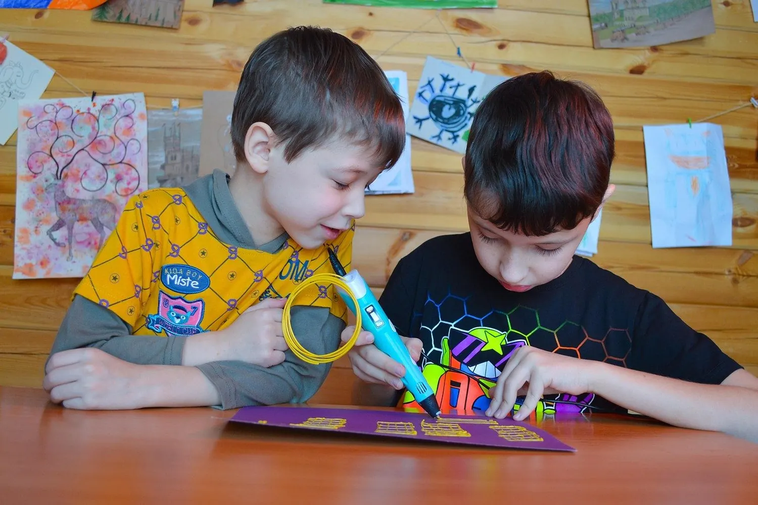 Deux enfants réalisant une création colorée avec un stylo 3D